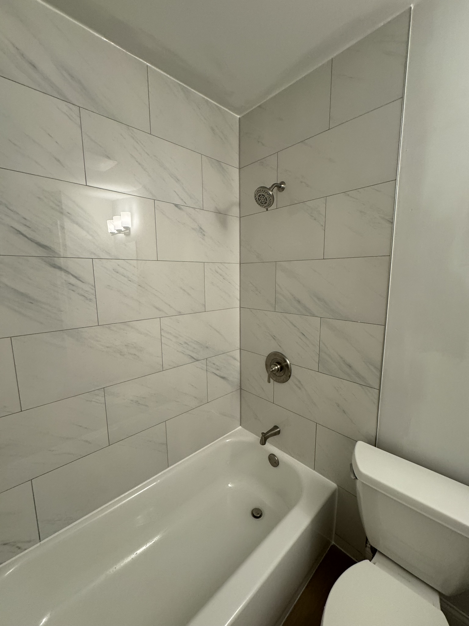 Completed bathroom remodeling with tiled bathtub surround in Aurora IL