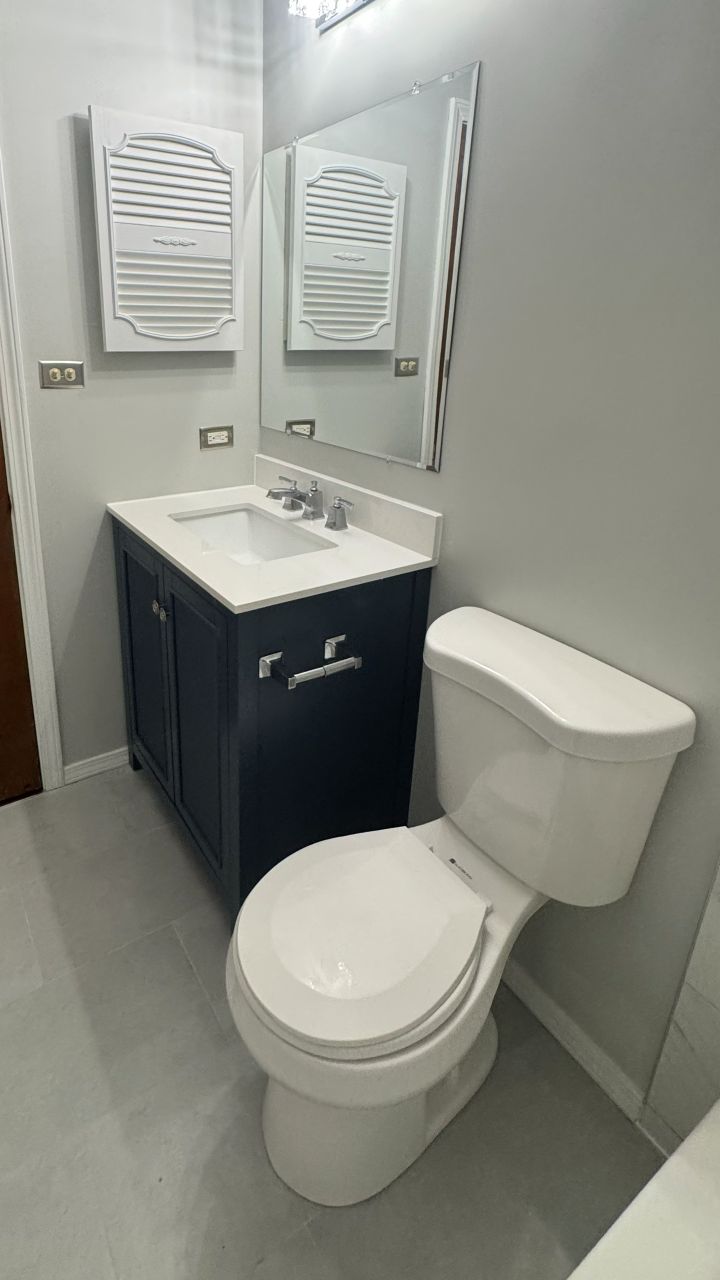 Updated bathroom lighting, vanity, mirror, and electrical fixtures.